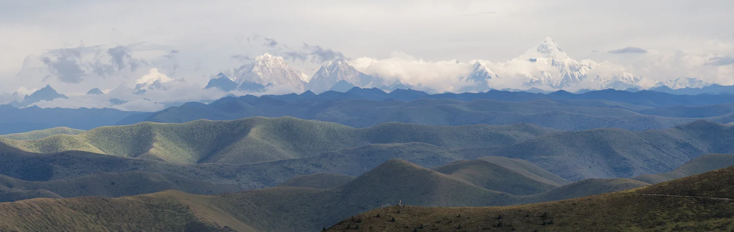 Layers of open mountain ridges stretch toward distant snow-covered peaks.